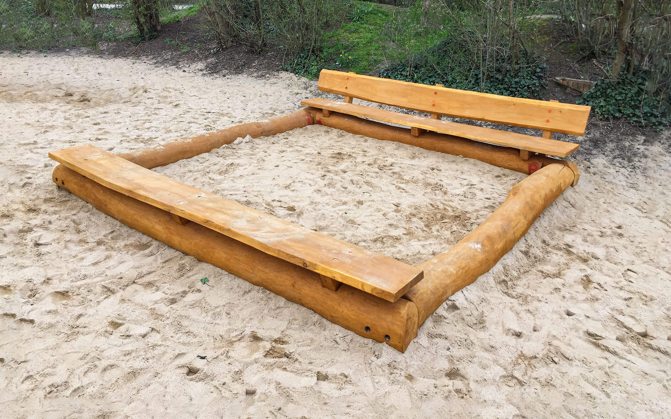 Sandkasten mit Sitzbänken